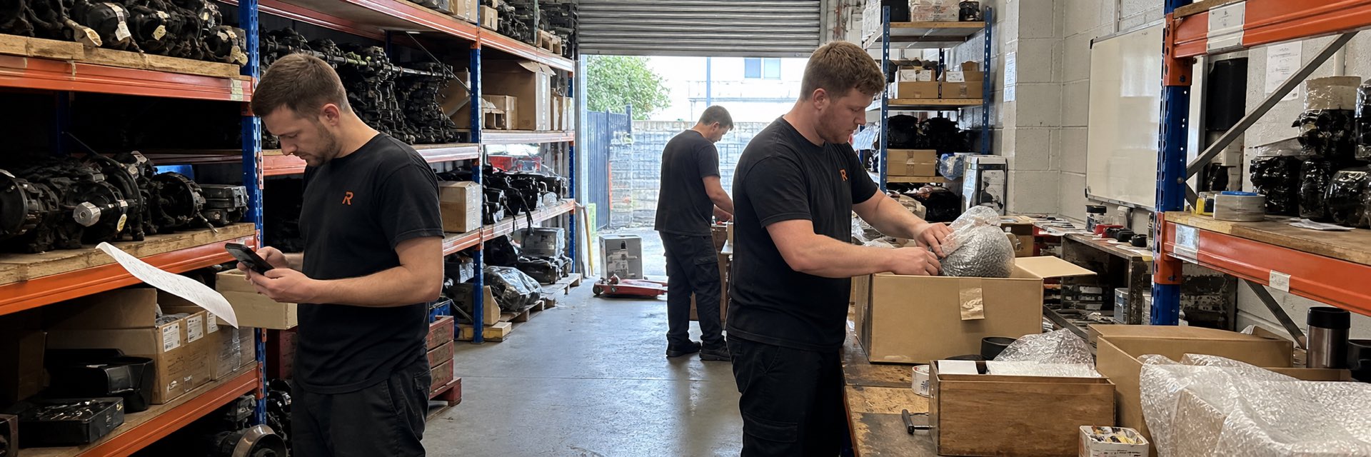 Staff picking and packing car parts orders in a UK parts warehouse